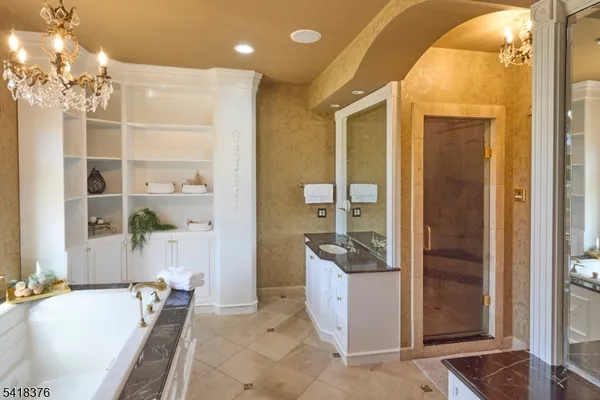a spacious bathroom with a granite countertop sink a mirror and shower