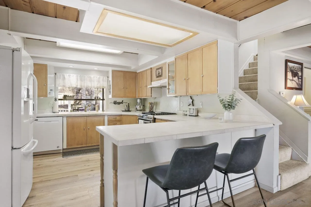9018 Vernal Lane Descanso, CA 91916 - Photo 5 of 56 a kitchen with a sink stools a counter space and cabinets