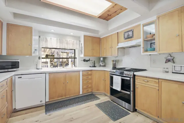 a kitchen with white cabinets and white appliances