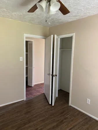 an empty room with wooden floor and entryway