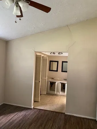 a view of a room with wooden floor and ceiling fan