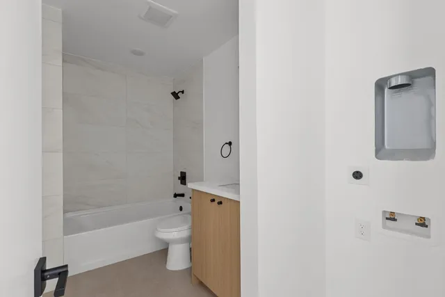 a bathroom with a granite countertop bathtub shower