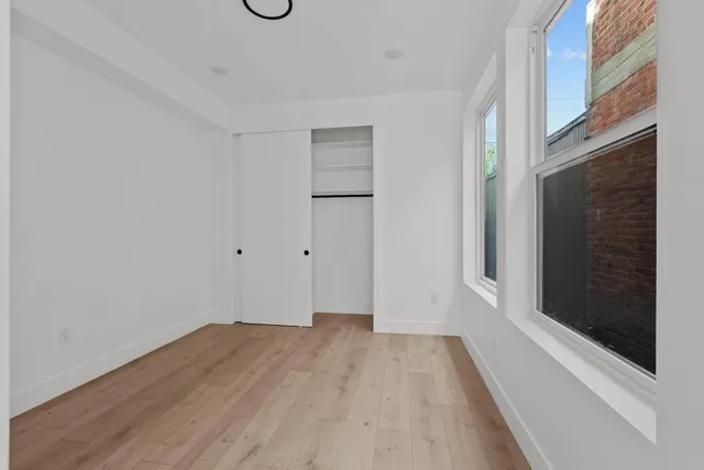 a view of a room with wooden floor and window