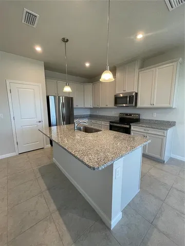 a kitchen with stainless steel appliances granite countertop a refrigerator sink and cabinets