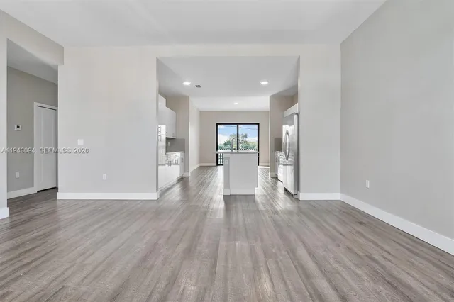 a view of a kitchen with wooden floor and electronic appliances
