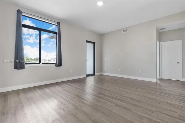 a view of a kitchen with wooden floor and a window