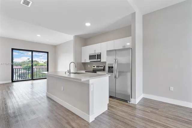a large kitchen with stainless steel appliances granite countertop a lot of counter space and a sink