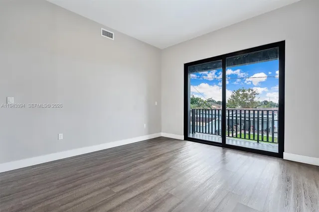 a view of an empty room with wooden floor