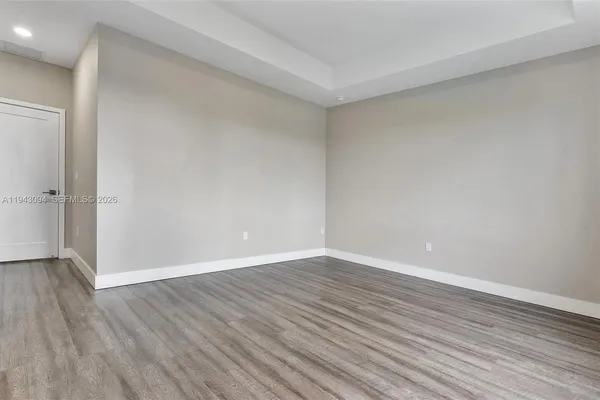 a view of an empty room with wooden floor