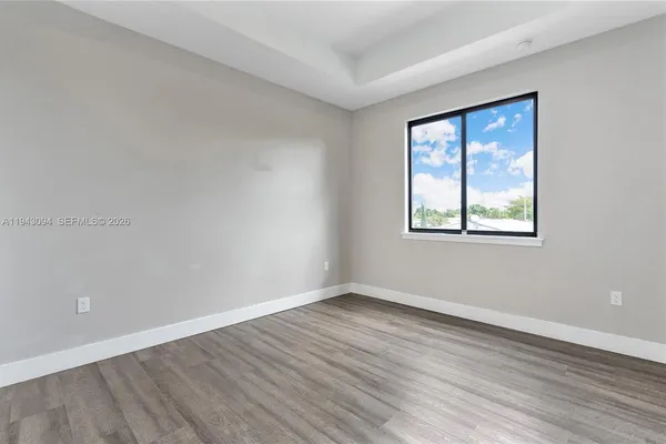 a view of an empty room with wooden floor