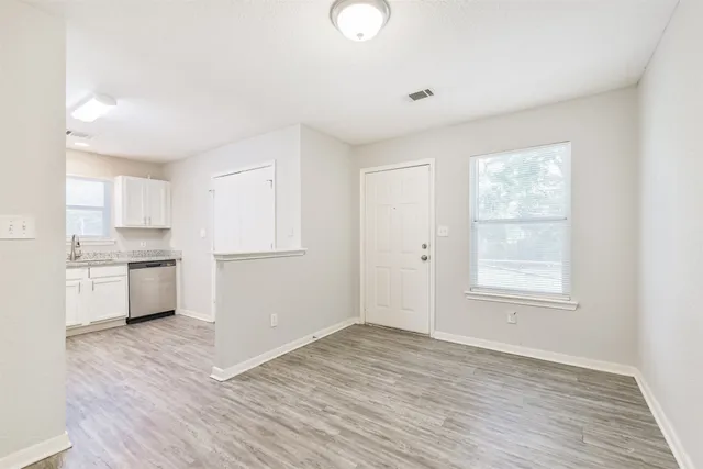 a view of a kitchen with wooden floor and electronic appliances