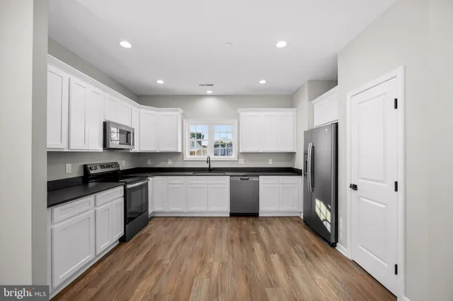 a kitchen with stainless steel appliances granite countertop a refrigerator and a sink