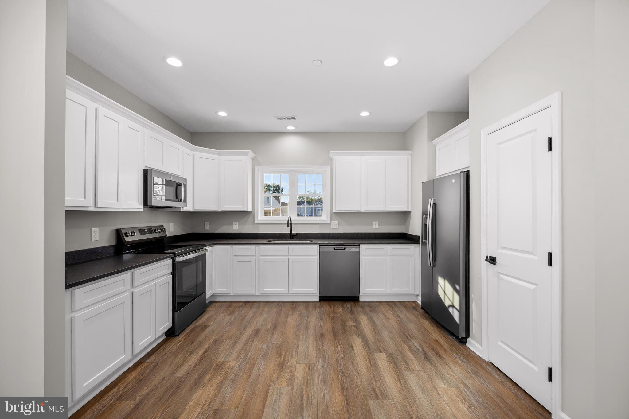 11775 St Stephens Way Princess Anne, MD 21853 - Photo 15 of 51 a large kitchen with stainless steel appliances granite countertop a large stove a sink dishwasher and a refrigerator with wooden floor