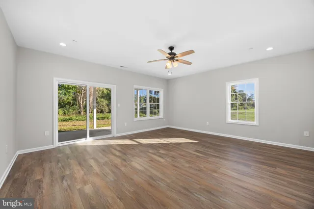 a view of an empty room with a kitchen and a window
