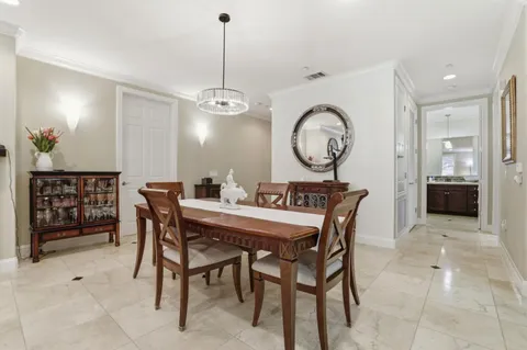 a view of a dining room and livingroom with furniture wooden floor a rug and a chandelier