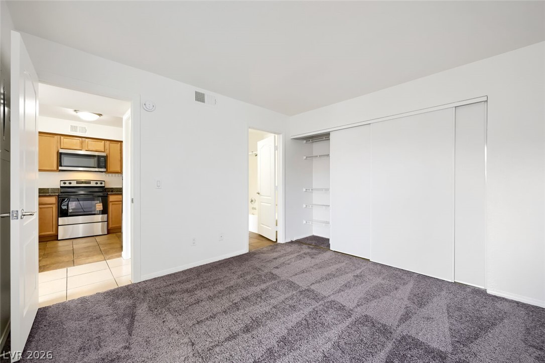 9325 West Desert Inn Road, Unit 177 Las Vegas, NV 89117 - Photo 15 of 24 Comfortable carpeted flooring extends throughout this versatile living space with direct kitchen access.