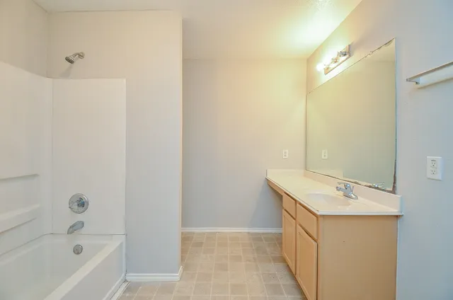 a bathroom with a sink a mirror and a bathtub