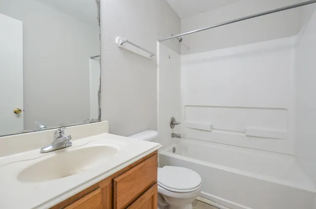 a bathroom with a sink toilet vanity and shower