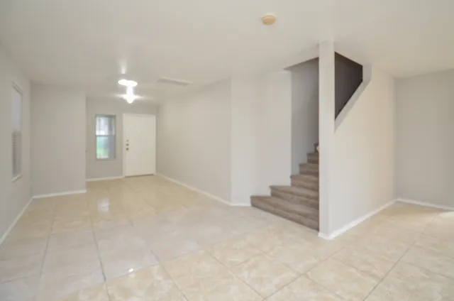 an empty room with staircase and white walls