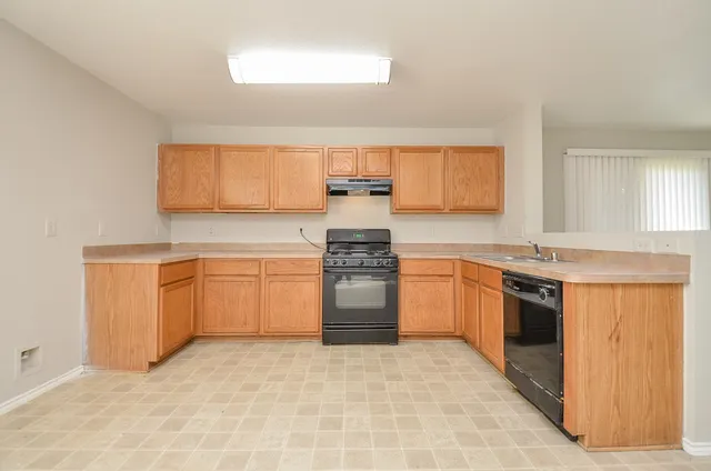 a kitchen with a stove top oven sink and cabinets