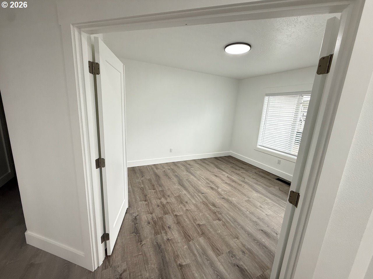 905 Monroe Street Harrisburg, OR 97446 - Photo 24 of 31 an empty room with wooden floor and windows