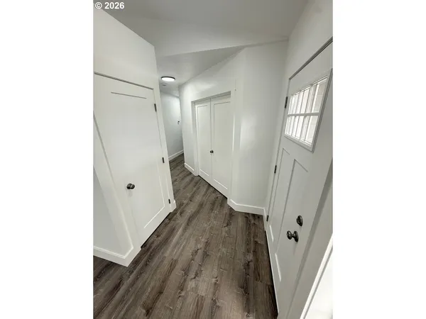 a view of a hallway with wooden floor and staircase