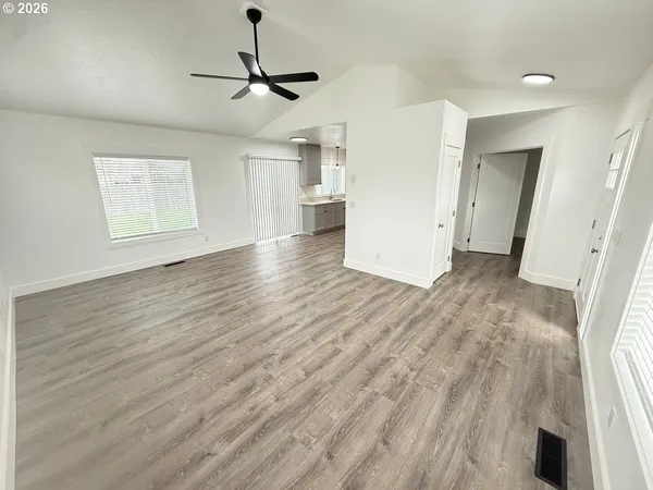 a view of empty room with wooden floor