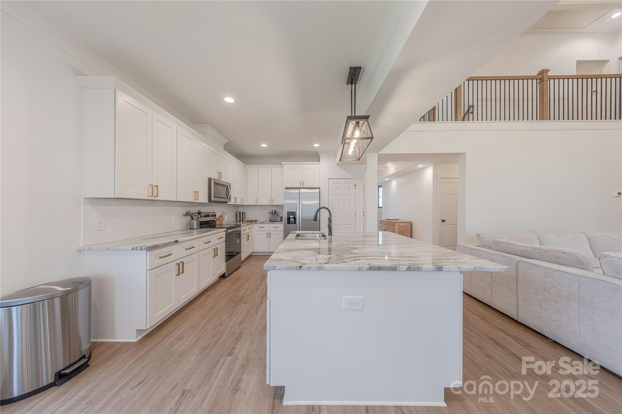 13625 Buster Road Stanfield, NC 28163 - Photo 11 of 43 a kitchen with stainless steel appliances granite countertop a sink dishwasher a stove and white cabinets with wooden floor