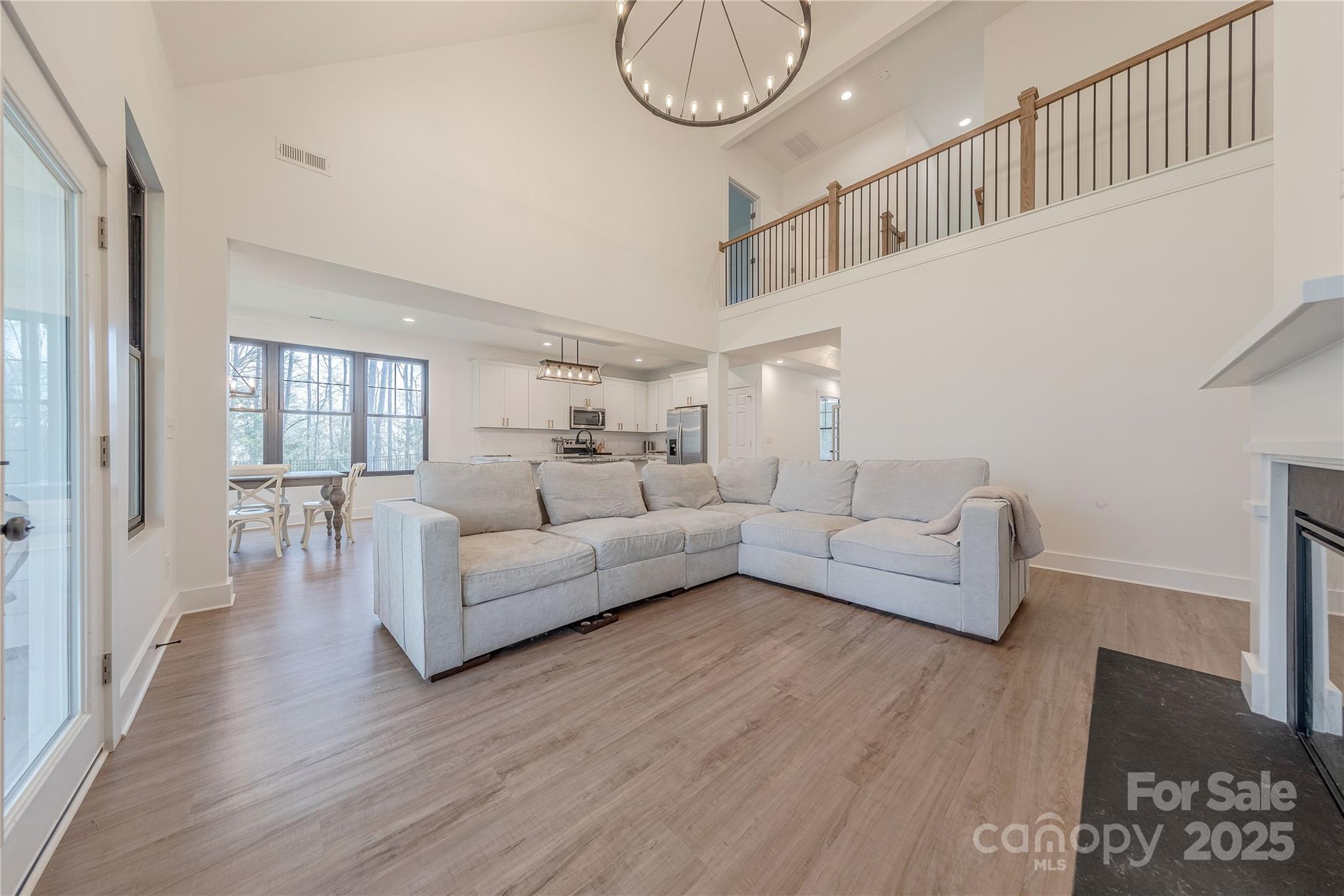 13625 Buster Road Stanfield, NC 28163 - Photo 18 of 43 a living room with furniture a wooden floor and a chandelier