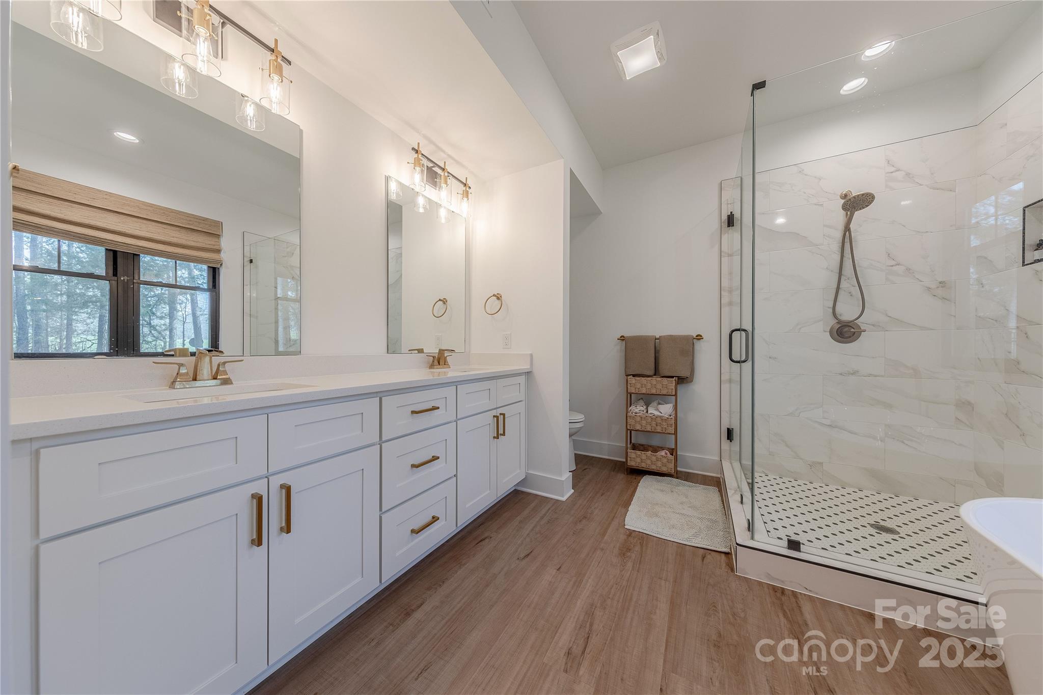 13625 Buster Road Stanfield, NC 28163 - Photo 24 of 43 a spacious bathroom with a double vanity sink a mirror and a shower