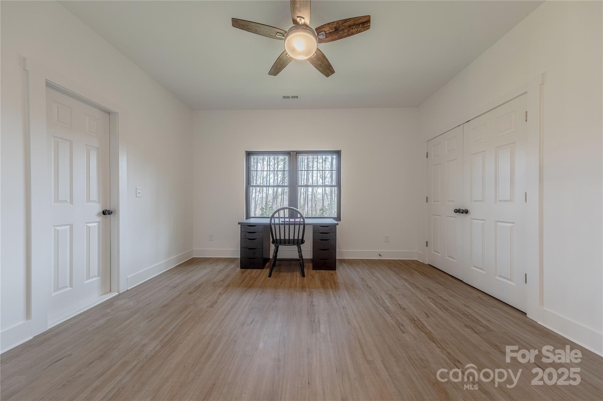 13625 Buster Road Stanfield, NC 28163 - Photo 29 of 43 an empty room with wooden floor fan and windows