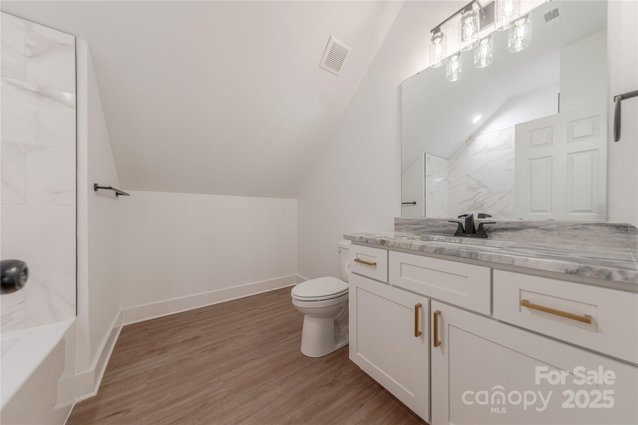 13625 Buster Road Stanfield, NC 28163 - Photo 35 of 43 a bathroom with a granite countertop toilet and a sink