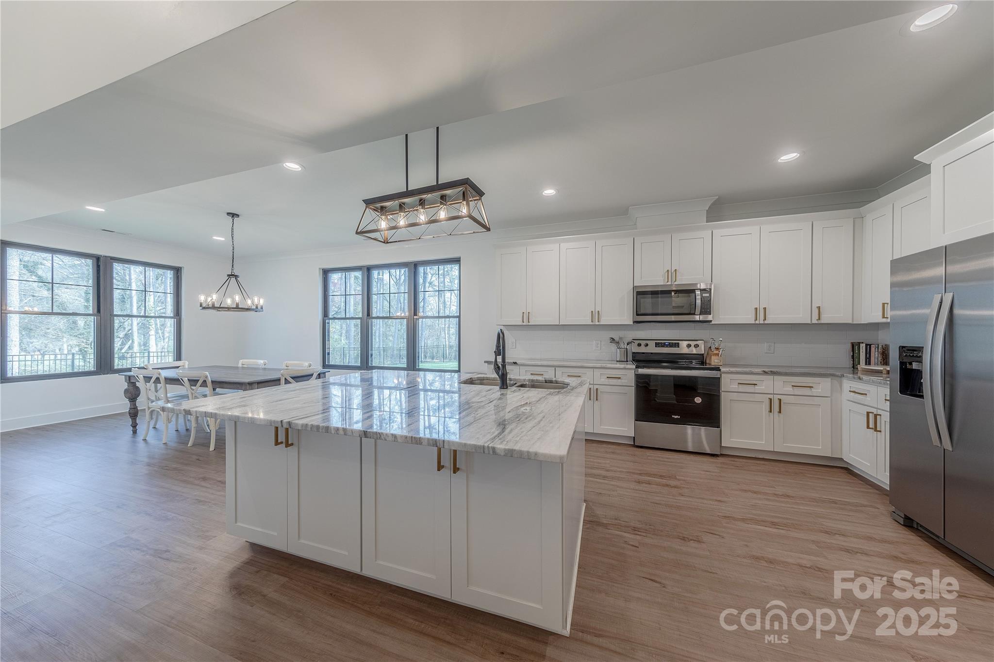 13625 Buster Road Stanfield, NC 28163 - Photo 8 of 43 a large kitchen with cabinets wooden floor and stainless steel appliances