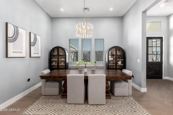a dining hall with stainless steel appliances kitchen island granite countertop a table and chairs in it