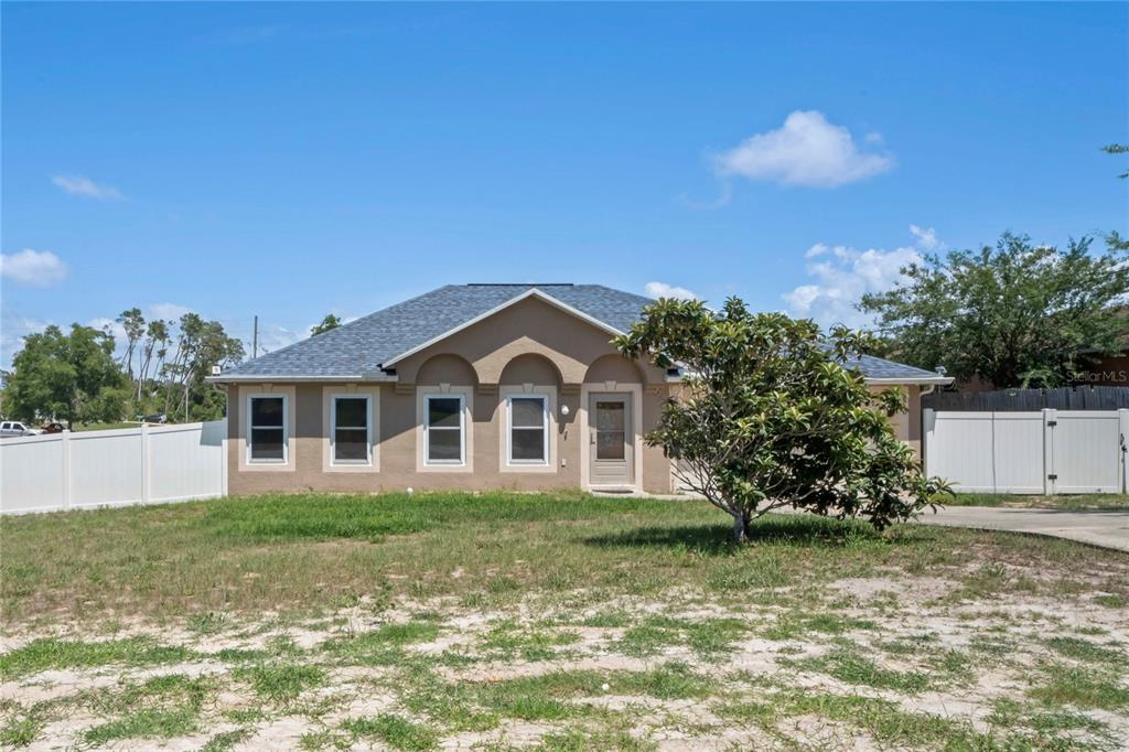 a front view of a house with a yard and trees