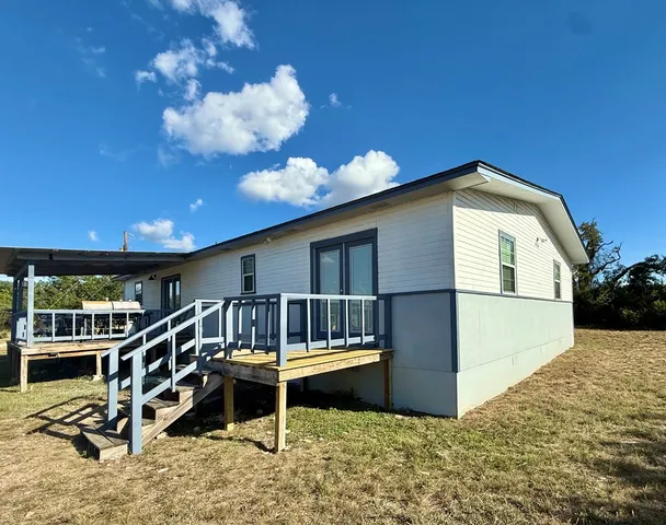 a view of a house with a wooden deck