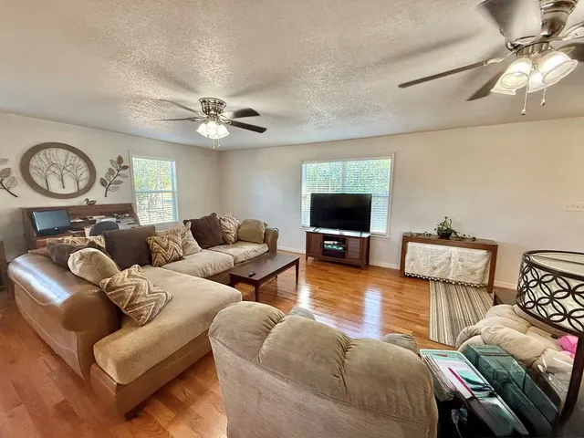 a living room with furniture a flat screen tv and a window