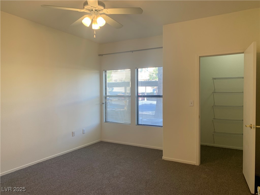 8250 North Grand Canyon Drive, Unit 1158 Las Vegas, NV 89166 - Photo 13 of 40 Unfurnished room featuring dark carpet and ceiling fan