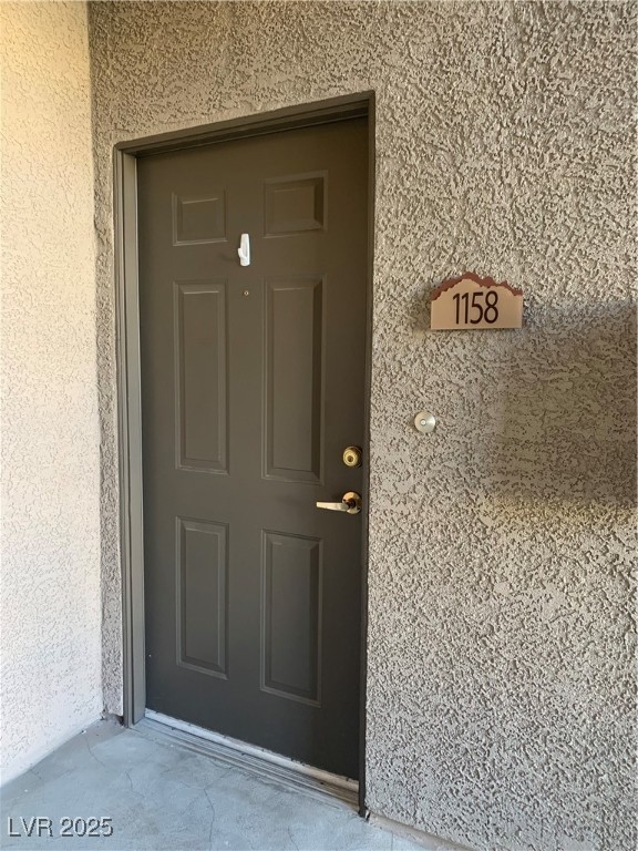 8250 North Grand Canyon Drive, Unit 1158 Las Vegas, NV 89166 - Photo 5 of 40 Doorway to property with stucco siding