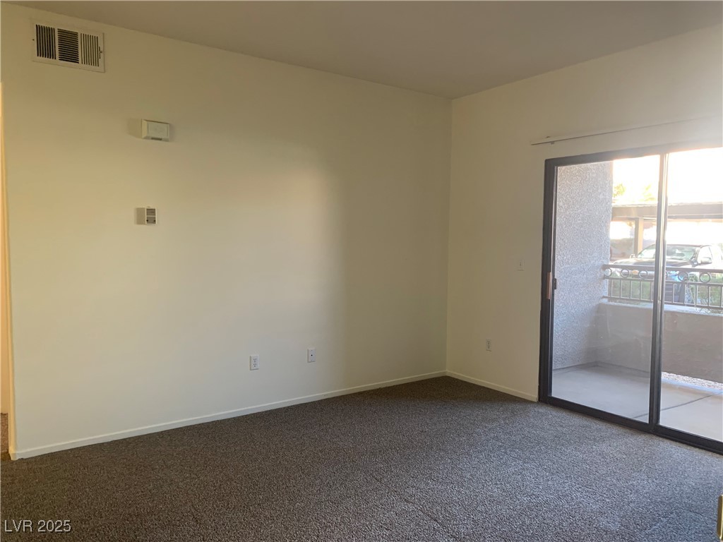 8250 North Grand Canyon Drive, Unit 1158 Las Vegas, NV 89166 - Photo 7 of 40 Empty room featuring dark colored carpet and baseboards