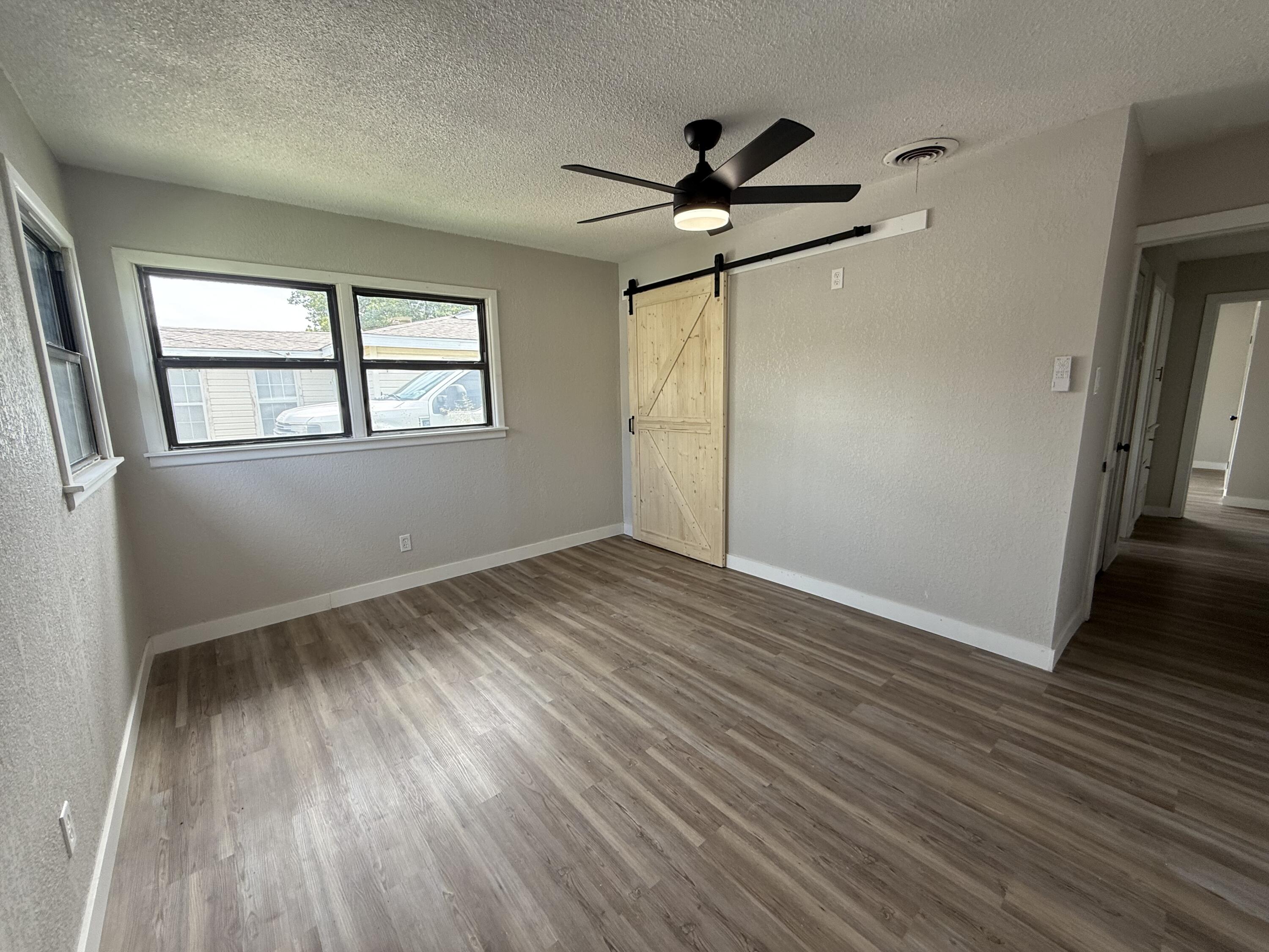 4308 43rd Street Lubbock, TX 79413 - Photo 16 of 28 a view of empty room with wooden floor and fan