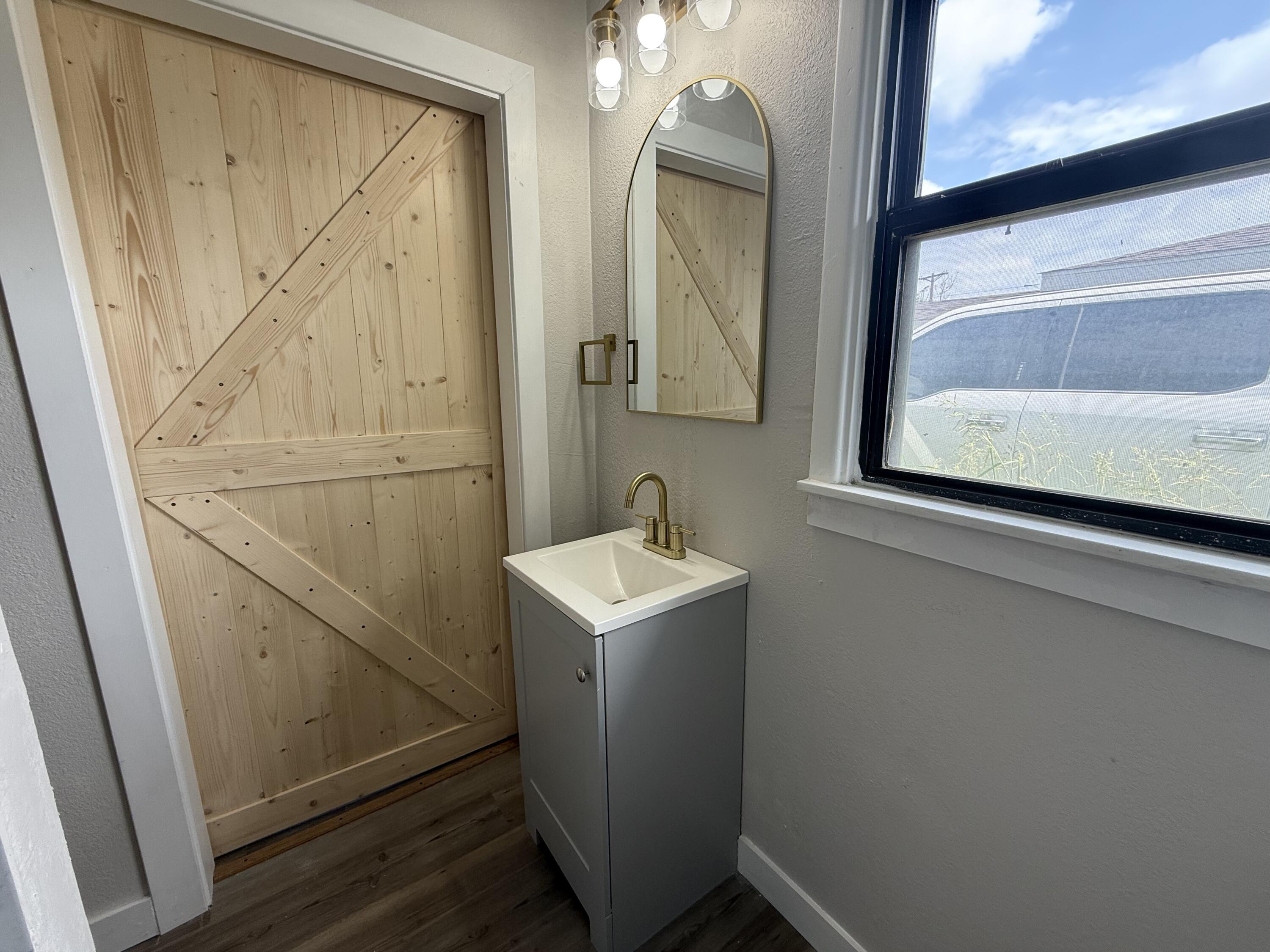 4308 43rd Street Lubbock, TX 79413 - Photo 20 of 28 a bathroom with a sink a mirror and vanity