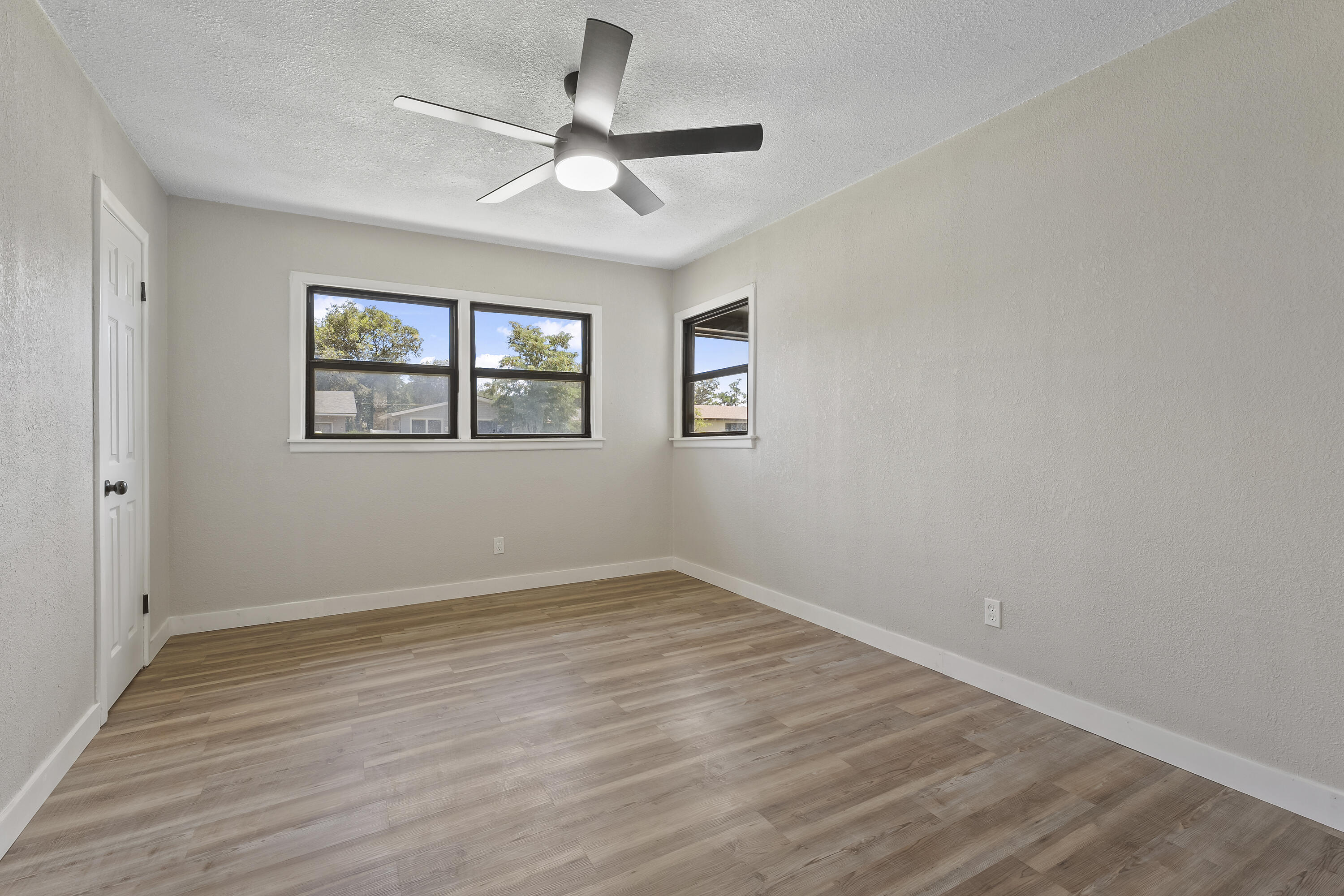4308 43rd Street Lubbock, TX 79413 - Photo 25 of 28 an empty room with wooden floor ceiling fan and windows