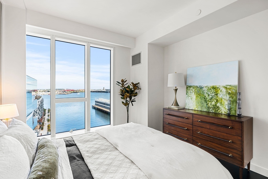 150 Seaport, Unit 9C Boston, MA 02210 - Photo 15 of 39 a bedroom with a bed and a dresser