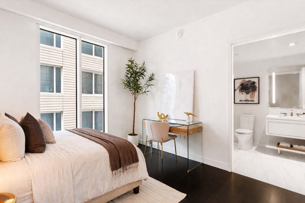 150 Seaport, Unit 9C Boston, MA 02210 - Photo 19 of 39 a bedroom with furniture and a potted plant
