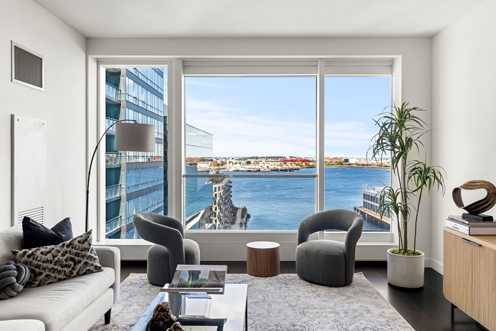 150 Seaport, Unit 9C Boston, MA 02210 - Photo 2 of 39 a living room with furniture and a potted plant
