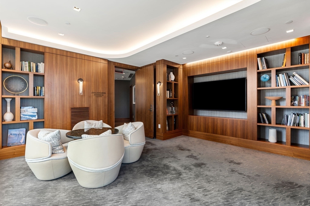 150 Seaport, Unit 9C Boston, MA 02210 - Photo 35 of 39 a living room with furniture a flat screen tv and a bookshelf