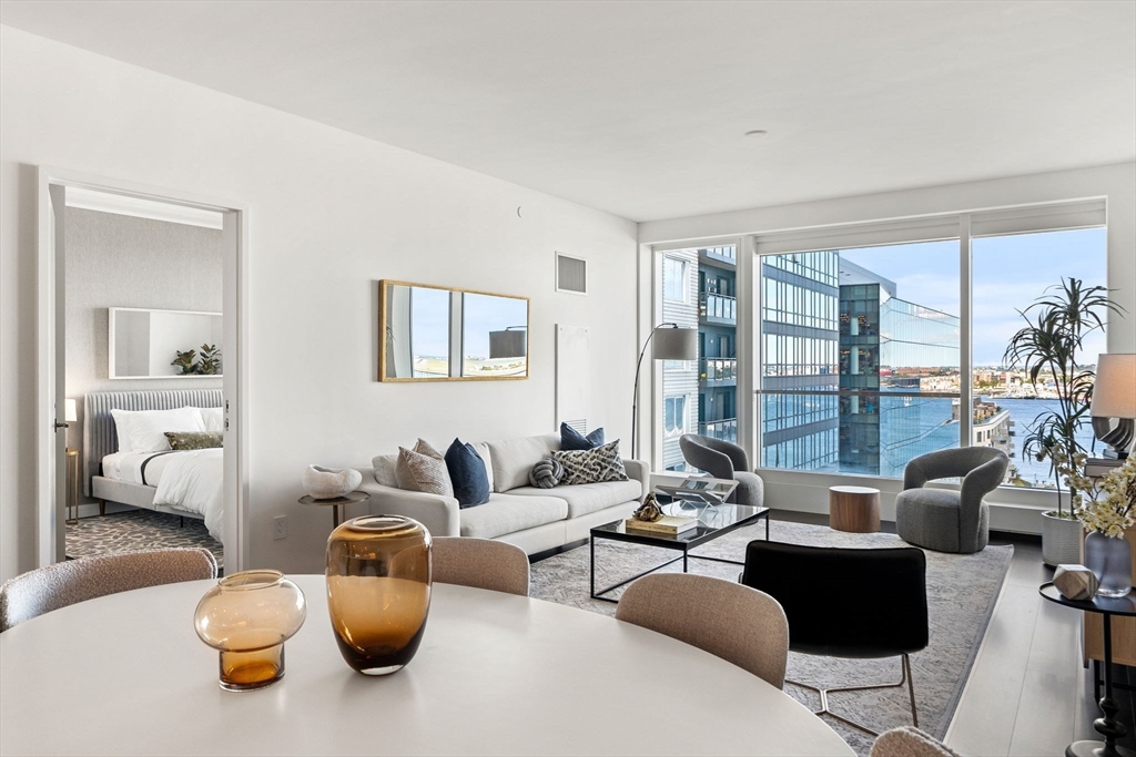 150 Seaport, Unit 9C Boston, MA 02210 - Photo 4 of 39 a living room with furniture and a large window