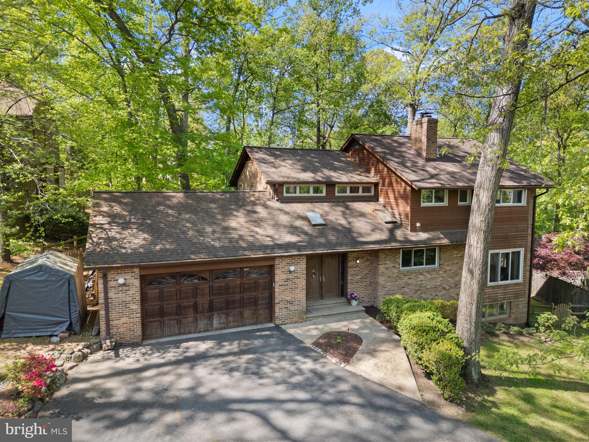 a front view of a house with a garden and tree