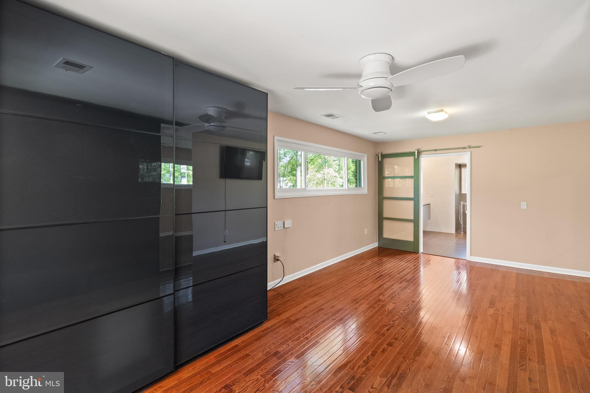 9220 Beech Hill Drive Bethesda, MD 20817 - Photo 22 of 50 an empty room with wooden floor cabinet and windows